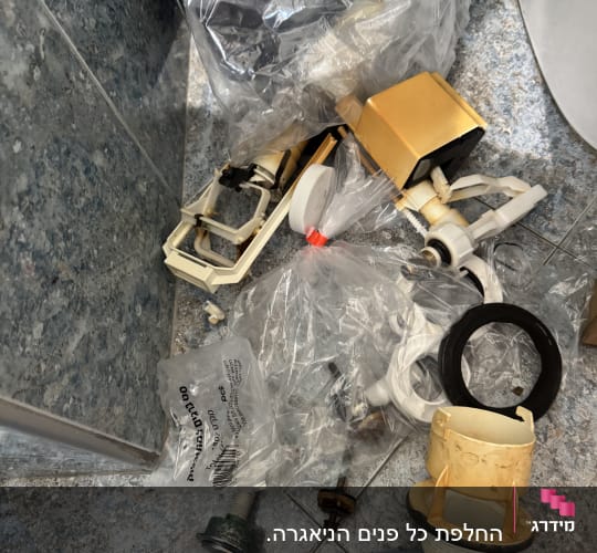 חלקי אינסטלציה וכלים על רצפת חדר אמבטיה
